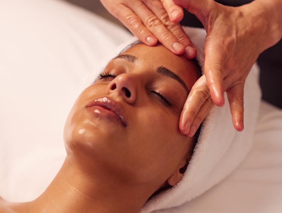 A woman receiving a facial massage treatment