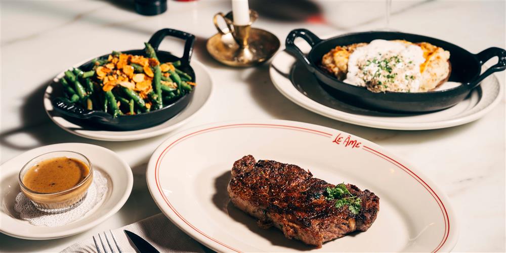 A glass of wine alongside a steak dinner