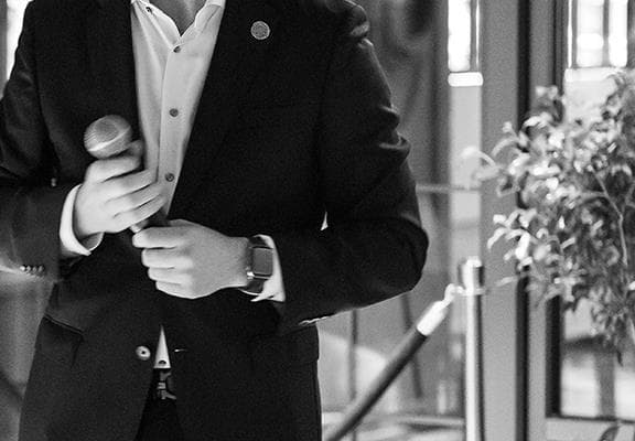 A guy in a suit holding a microphone